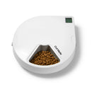 Ein weißer automatischer Fünf-Mahlzeiten-Haustierfütterer mit digitalem Timer von 'Cat Mate', mit dem Markennamen in dunkler Schrift an der Seite neben dem offenen Napf mit Trockenfutter, vor weißem Hintergrund