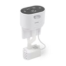 Weiße automatische Wasserpumpeneinheit mit einem dunkelgrauen oberen Bedienfeld mit drei Symbolen (WLAN/Signal, Uhr/Timer und Wasserfluss), einem Bewegungssensor und einer Status‑LED an der Vorderseite. Zwei gebogene, flexible Schläuche führen vom Sockel zu einer kleinen weißen Tauchpumpen‑Box mit Belüftungsschlitzen, die über ein Kabel angeschlossen ist.