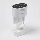 Eine Brunnenpumpe mit einem schwarzen Touch‑Bedienfeld oben, das Wireless‑, Timer‑ und USB‑Symbole sowie eine Ein/Aus‑Taste und einen Bewegungssensor zeigt. Das Gerät besitzt einen flexiblen Hals, der zu einer kleinen weißen, perforierten Ausgabeeinheit am Sockel führt, neben der ein Kabel in einen Netzadapter eingesteckt ist.